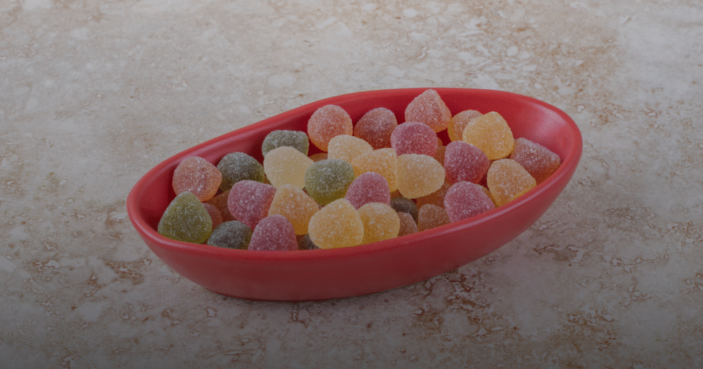 A colorful bowl filled with various gummy candies, showcasing different shapes and vibrant hues.